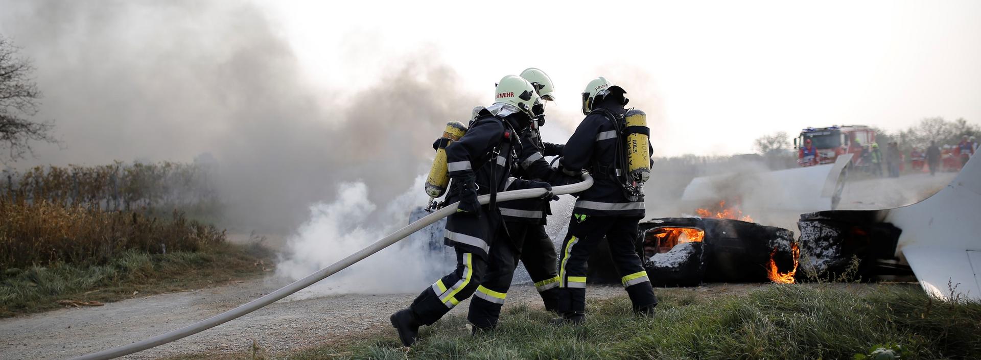 Feuerwehr beim Löschen eines Autobrandes